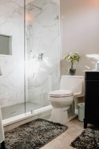 Someone demonstrating proper use of a toilet plunger in a residential bathroom.