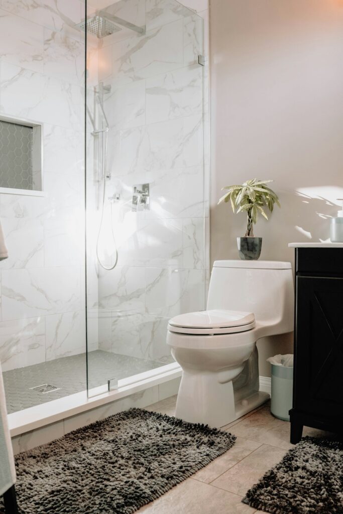 Someone demonstrating proper use of a toilet plunger in a residential bathroom.